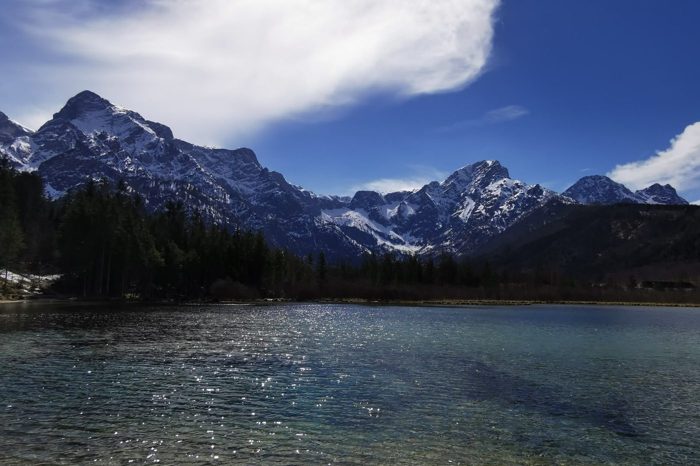 Ruhiger Bergsee vor schneebedeckten Gipfeln