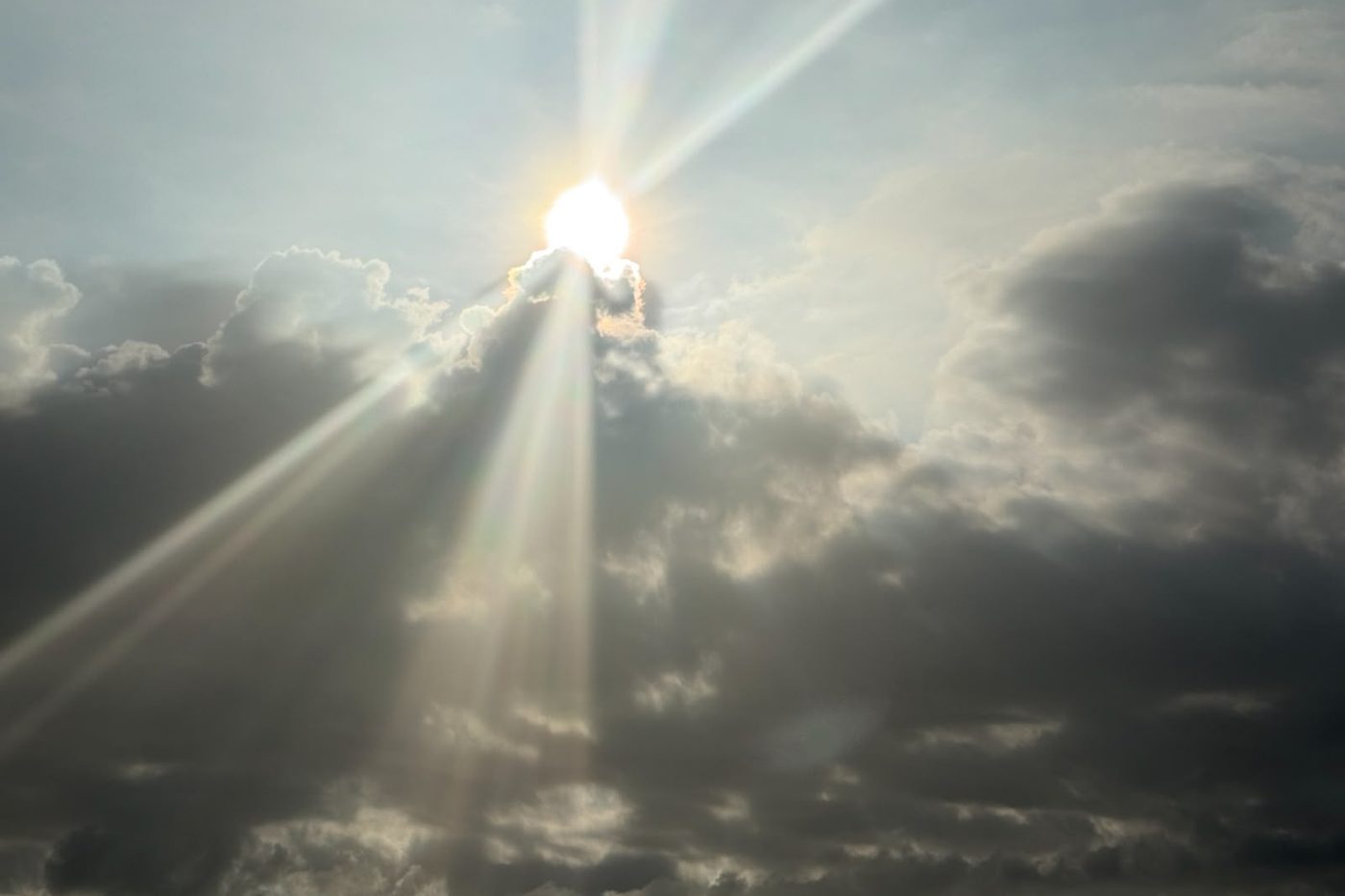 Sonnenstrahlen brechen durch dunkle Wolken